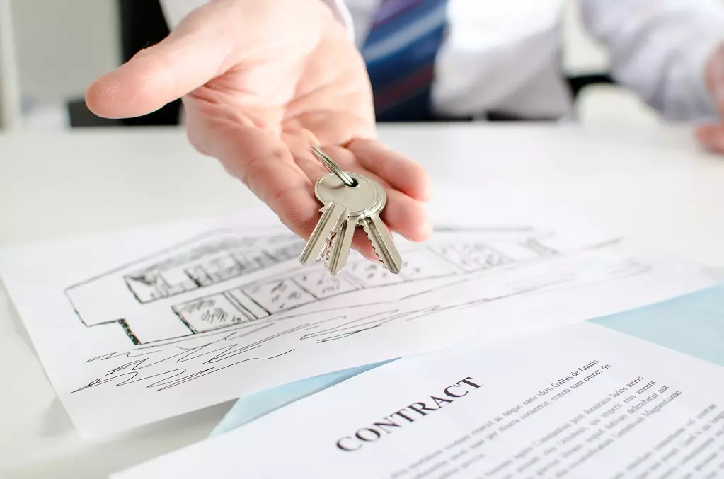 Mature couple with estate agent in office